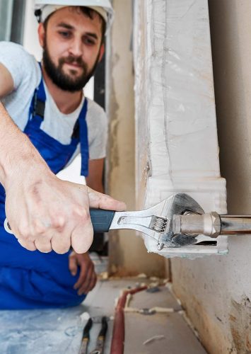 male-worker-installing-heating-radiator-in-apartme-2025-01-16-22-06-44-FRQK54S.jpg